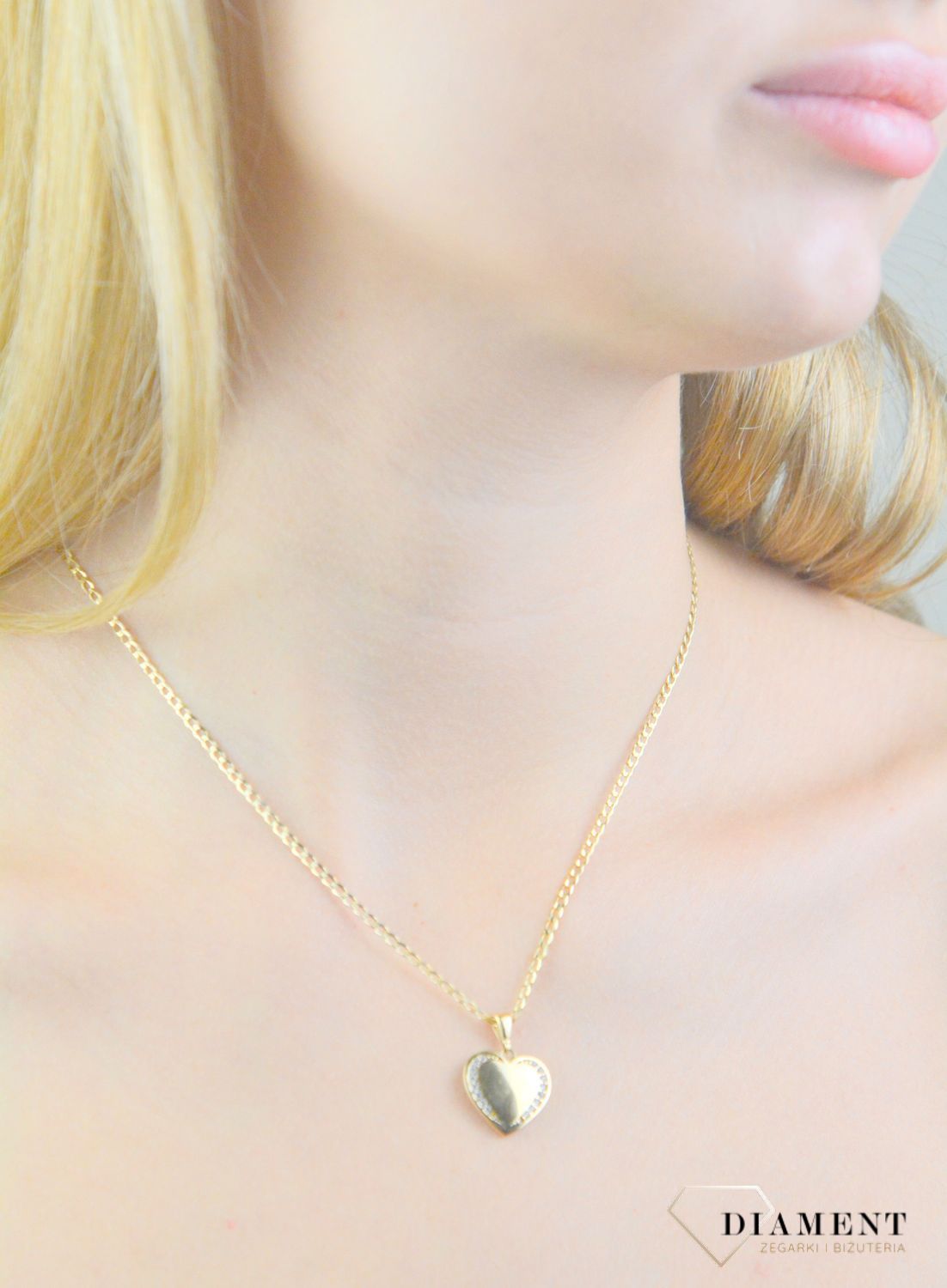 Piękna zawieszka w kształcie serca ozdobiona białą cyrkonią. Zawieszkę wykonano ze złota próby 585 o wadze 1,95 gram. Do zawieszki można dobrać delikatny złoty łańcuszek, który można znaleźć w naszej ofercie.  (2).jpg